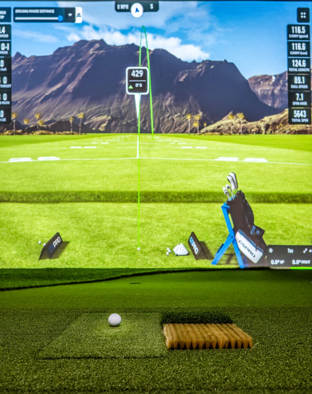 Simulator hitting mat and tee area in front of a driving range projection