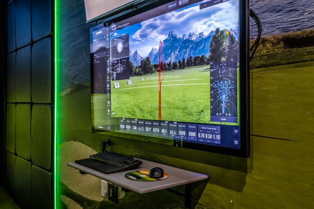 Wall-mounted second screen displaying GSPro shot data and swing analytics