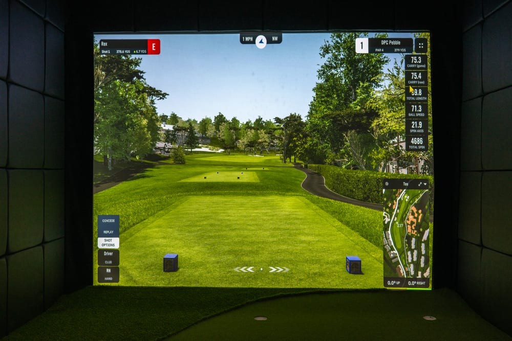 Custom golf simulator impact screen showing a course view and live shot data