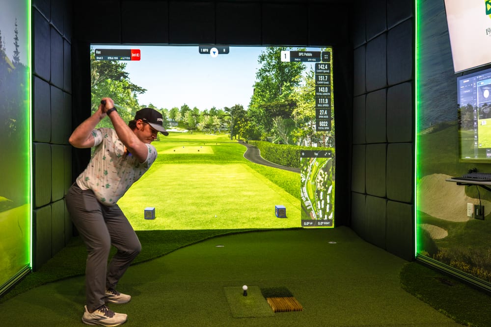 Golfer at the top of the backswing in a custom home golf simulator